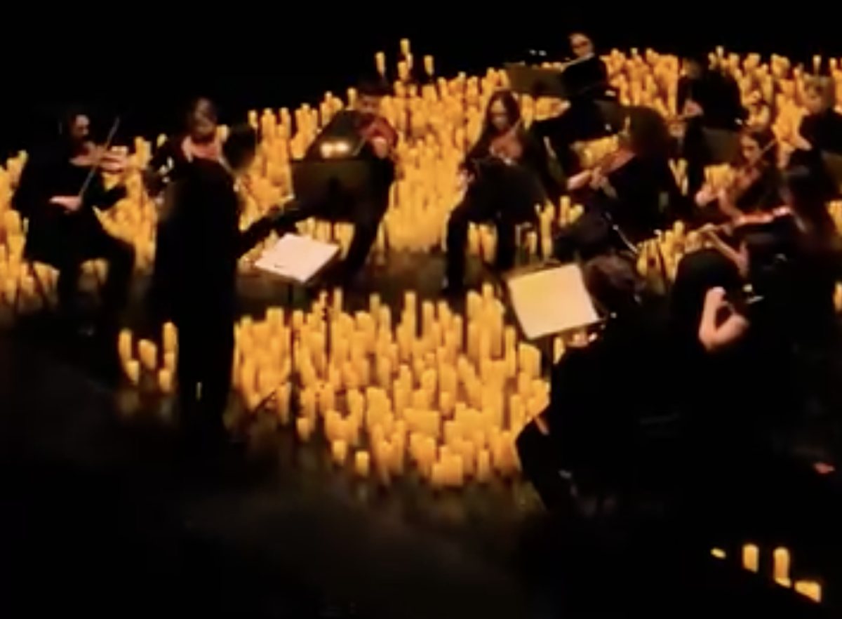 A string quartet performing surrounded by candles at a Music by Candlelight concert