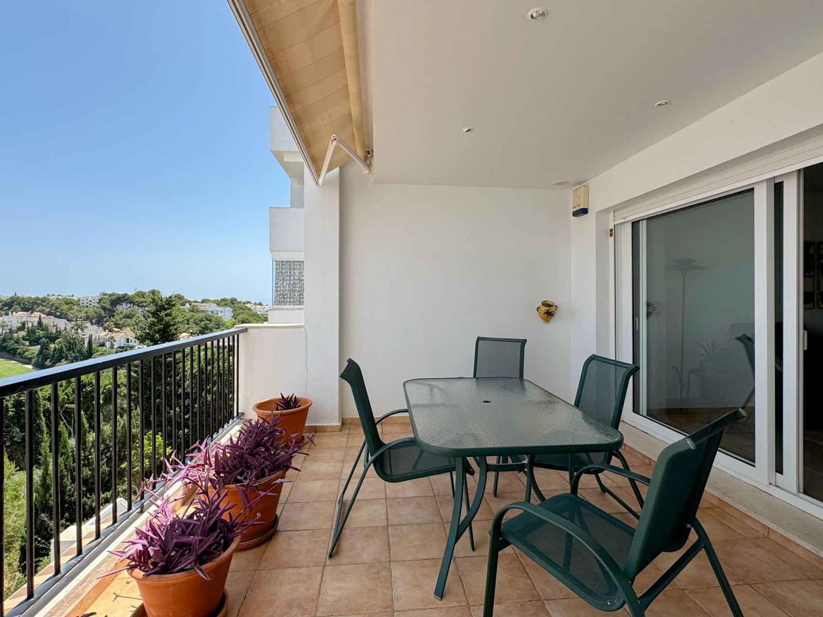 Covered terrace with dining table overlooking the golf course